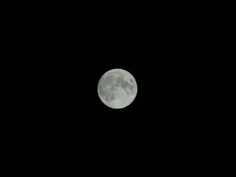 An amazing photography of the full moon over the city of Genova by night with a great clear sky in background and some stars