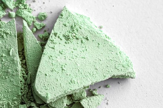 Green eye shadow powder as makeup palette closeup isolated on white background, crushed cosmetics and beauty textures