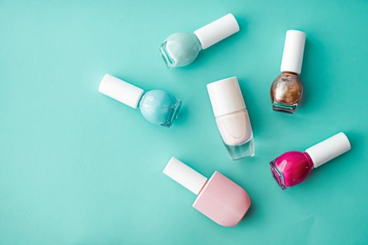 Nail polish bottles on green background, beauty branding