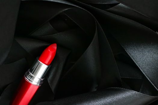 Red lipstick on black silk background, luxury make-up and beauty cosmetics