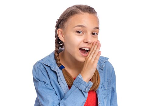 Happy teenage girl whispers, says something, covering her mouth with a palm, isolated on white background