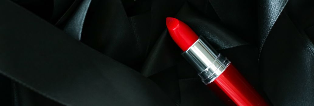 Red lipstick on black silk background, luxury make-up and beauty cosmetics