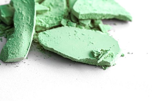 Green eye shadow powder as makeup palette closeup isolated on white background, crushed cosmetics and beauty textures