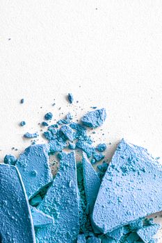 Blue eye shadow powder as makeup palette closeup isolated on white background, crushed cosmetics and beauty textures
