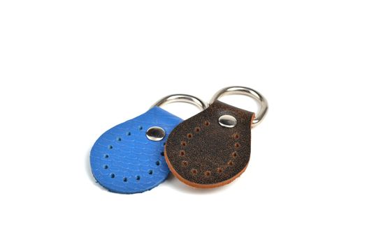 Blank blue brown round color leather key chain collection on isolated white background with clipping path. Pile set of metallic souvenir.