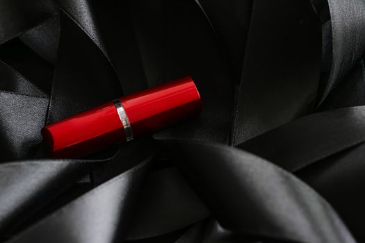 Red lipstick on black silk background, luxury make-up and beauty cosmetics