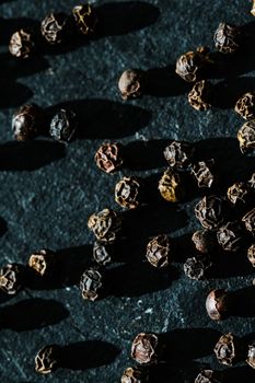 Black pepper closeup on luxury stone background as flat lay, dry food spices and recipe ingredients