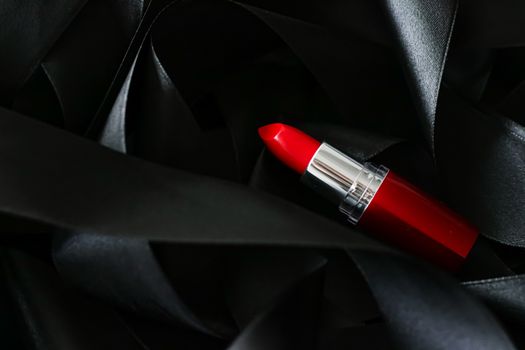 Red lipstick on black silk background, luxury make-up and beauty cosmetics