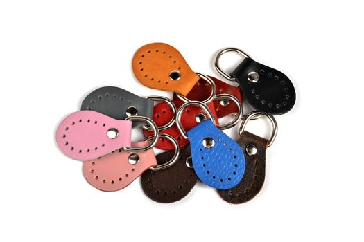 Blank round color leather key chain collection on isolated white background with clipping path. Pile set of metallic souvenir.