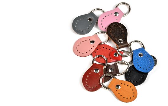 Blank round color leather key chain collection on isolated white background with clipping path. Pile set of metallic souvenir.
