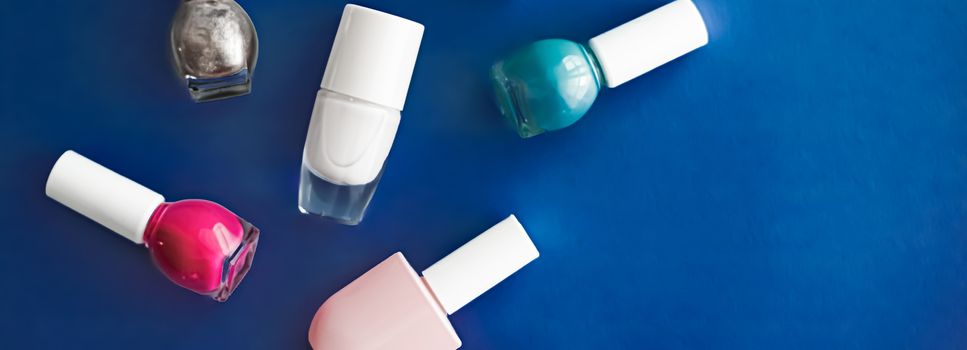 Nail polish bottles on dark blue background, beauty branding