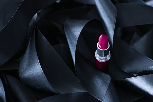 Purple lipstick on black silk background, luxury make-up and beauty cosmetics