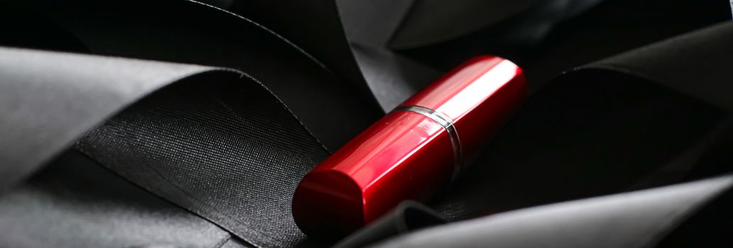 Red lipstick on black silk background, luxury make-up and beauty cosmetics