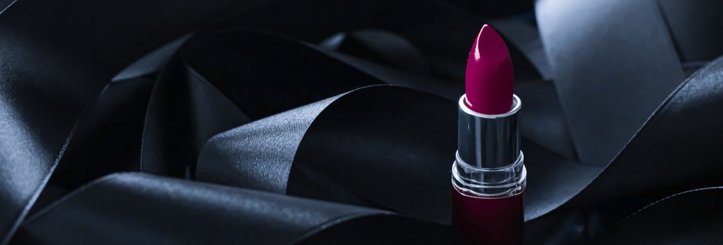 Purple lipstick on black silk background, luxury make-up and beauty cosmetics