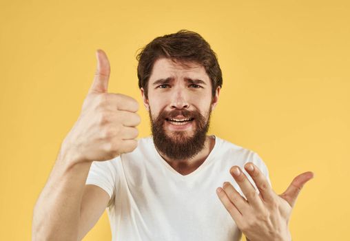 Man shows positive hand gesture emotions fun yellow background. High quality photo