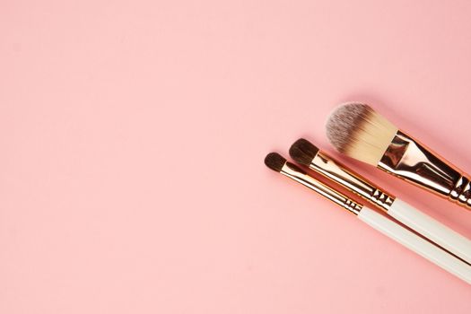 makeup brushes and eyeshadow professional cosmetics on pink background. High quality photo