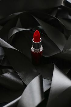 Red lipstick on black silk background, luxury make-up and beauty cosmetics