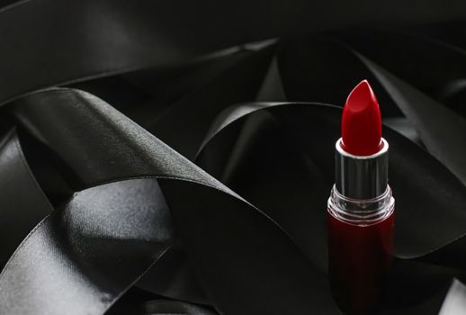 Red lipstick on black silk background, luxury make-up and beauty cosmetics