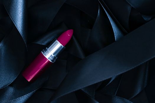 Purple lipstick on black silk background, luxury make-up and beauty cosmetics