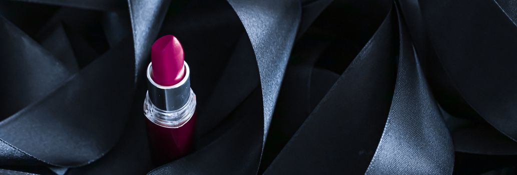 Purple lipstick on black silk background, luxury make-up and beauty cosmetics