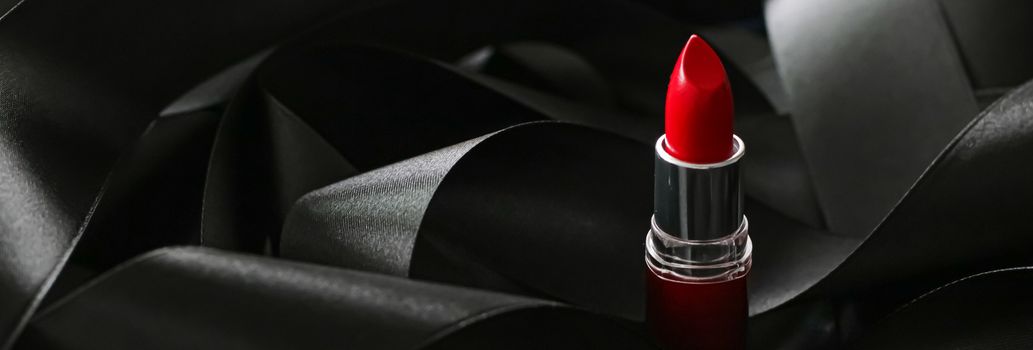 Red lipstick on black silk background, luxury make-up and beauty cosmetics