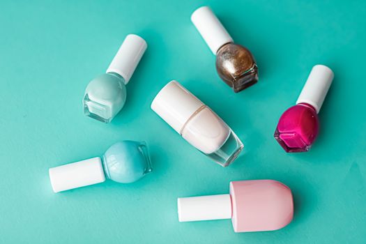 Nail polish bottles on green background, beauty branding