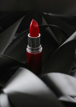 Red lipstick on black silk background, luxury make-up and beauty cosmetics