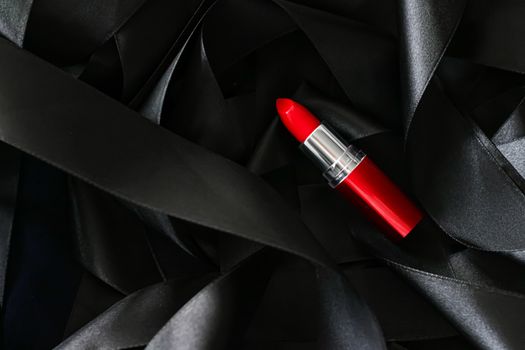 Red lipstick on black silk background, luxury make-up and beauty cosmetics