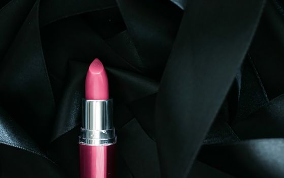 Pink lipstick on black silk background, luxury make-up and beauty cosmetics