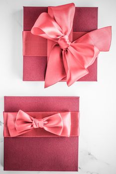 Birthday, wedding and girly branding concept - Coral gift box with silk bow on marble background, girl baby shower present and glamour fashion gift for luxury beauty brand, holiday flatlay art design