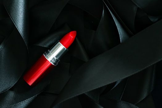 Red lipstick on black silk background, luxury make-up and beauty cosmetics