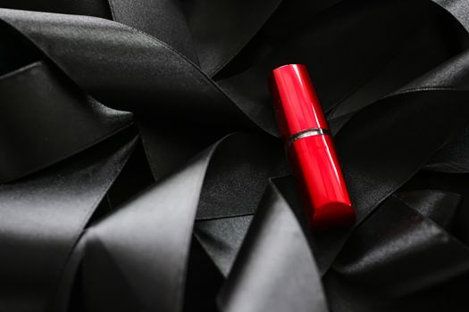 Red lipstick on black silk background, luxury make-up and beauty cosmetics