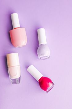 Nail polish bottles on purple background, beauty branding