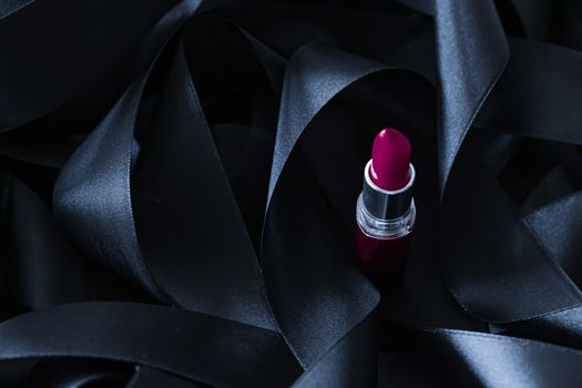 Purple lipstick on black silk background, luxury make-up and beauty cosmetics