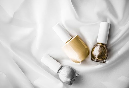 Cosmetic branding, salon and glamour concept - Nail polish bottles on silk background, french manicure products and nailpolish make-up cosmetics for luxury beauty brand and holiday flatlay art design