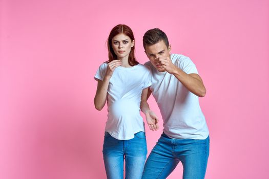 pregnant mom and happy father on pink background Young family waiting for baby. High quality photo