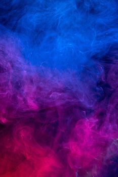 Conceptual image of colorful red and blue color smoke isolated on dark black background, Halloween concept design element.