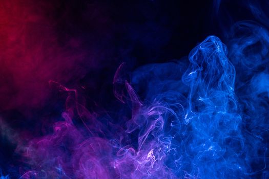 Conceptual image of colorful red and blue color smoke isolated on dark black background, Halloween concept design element.