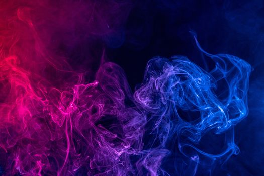 Conceptual image of colorful red and blue color smoke isolated on dark black background, Halloween concept design element.
