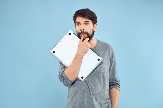 Bearded man laptop in hand internet wireless technology emotions blue background. High quality photo