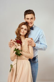 Young couple hugs romance dating lifestyle relationship light background red rose. High quality photo