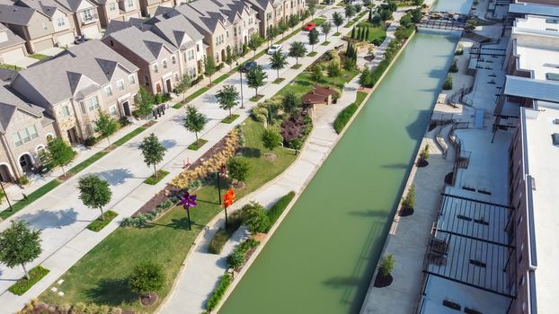 Riverside brand new townhouses and business mall strips along canal in downtown Flower Mound, Texas, America. Aerial new urban style residential neighborhood and commercial area