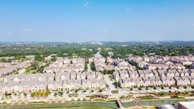 Aerial view of brand new riverside two story condo, townhomes and apartment complex in downtown Flower Mound, Texas, US. Master-planned community and census-designated residential houses