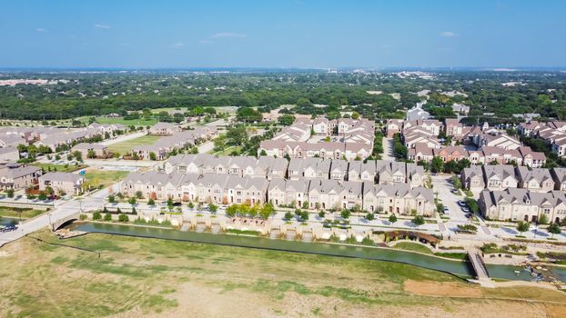 New development riverside master-planned residential neighborhood, business area in download Flower Mound, Texas, US. Top view brand new townhouses, apartment complex near large vacant land