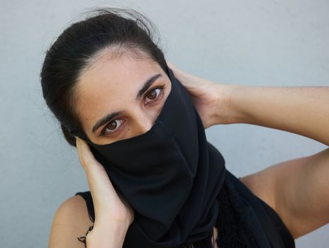 Una joven y atractiva mujer con un pañuelo negro en la cabeza