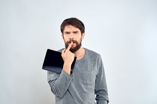 emotional man holding tablet technology communication internet work light background. High quality photo