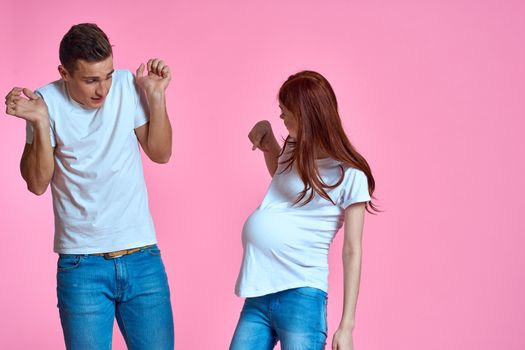 pregnant mom and happy father on pink background Young family waiting for baby. High quality photo