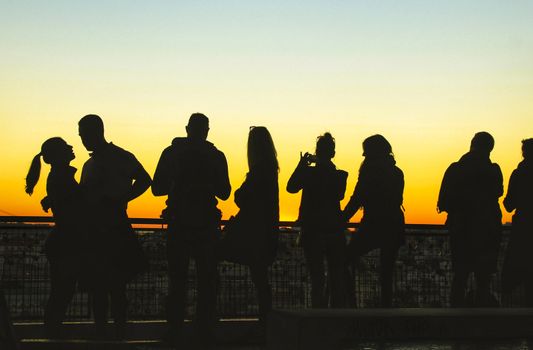 People watching a beautiful sunset in a viewpoint of Lisbon in Autumn