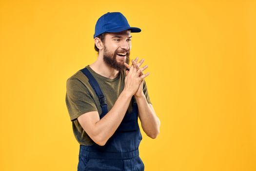 Worker man in uniform worker service yellow background emotion. High quality photo