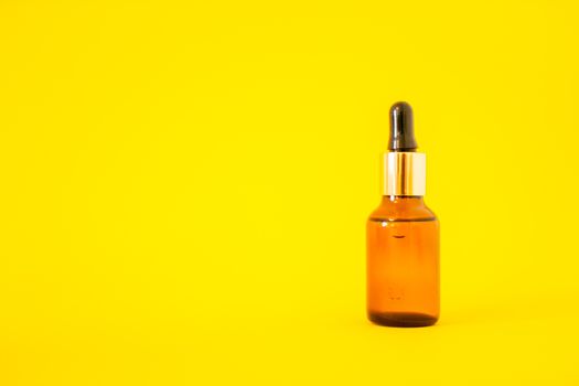 Cosmetic bottles with serum on a bright yellow background. Cosmetology and beauty concept.